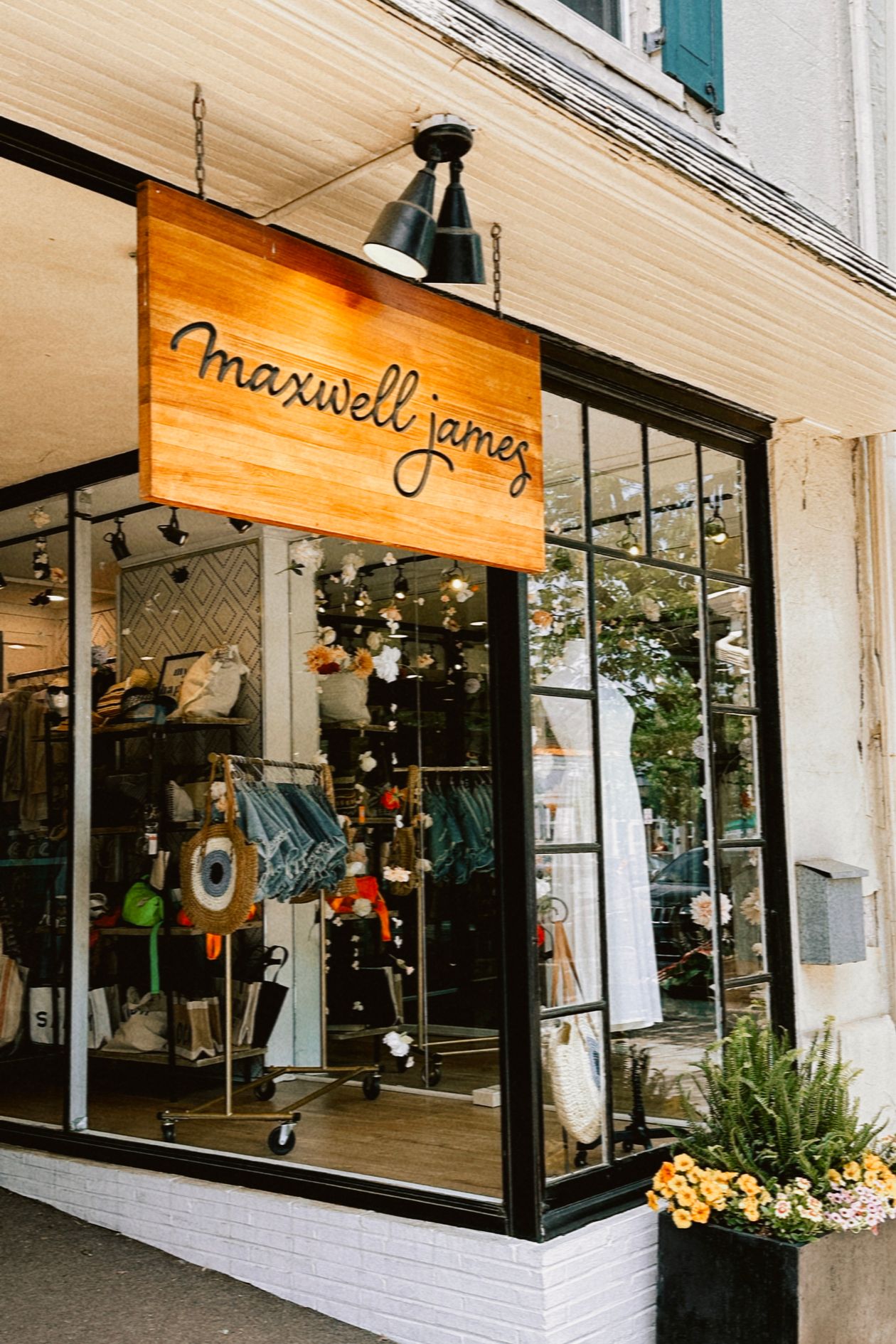 Exterior view of a boutique shopfront with stylish wooden sign and professional window display