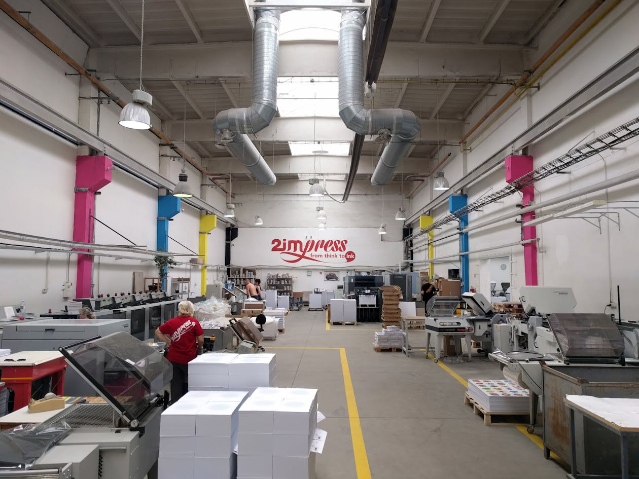 Workers operating large format printing equipment in a modern printing facility