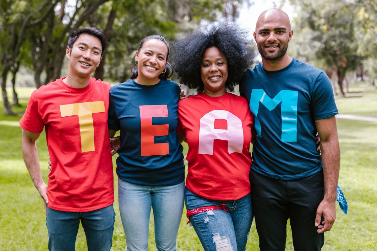 Group wearing colourful printed T-shirts spelling TEAM