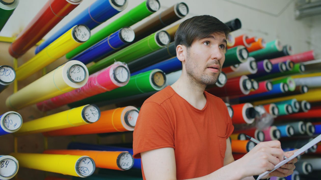Person reviewing print materials for event banner display in a print shop