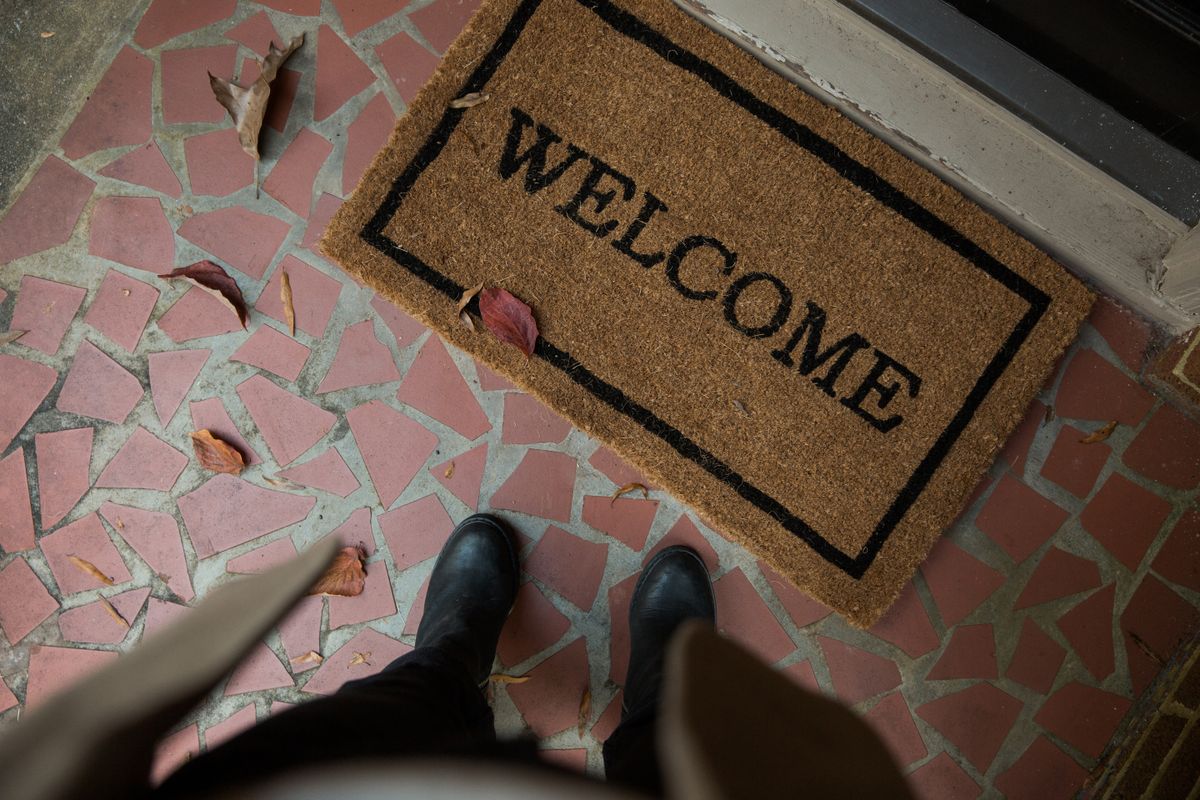 Printed coir entrance mat reading Welcome outside a doorway