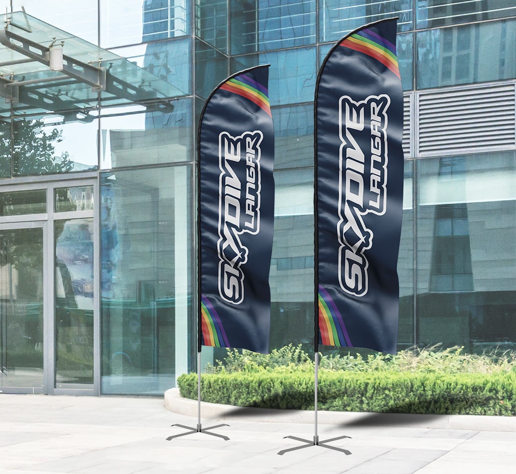Two feather flags reading Skydive Langar outside a modern glass building
