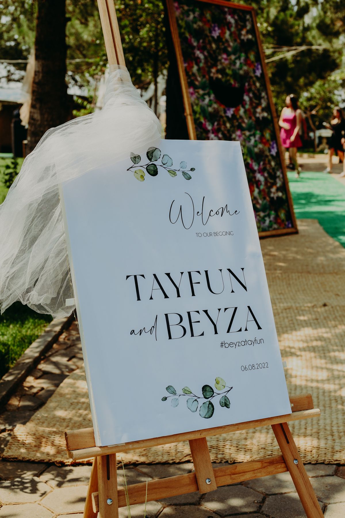 Printed welcome sign display board on a wooden easel at a wedding