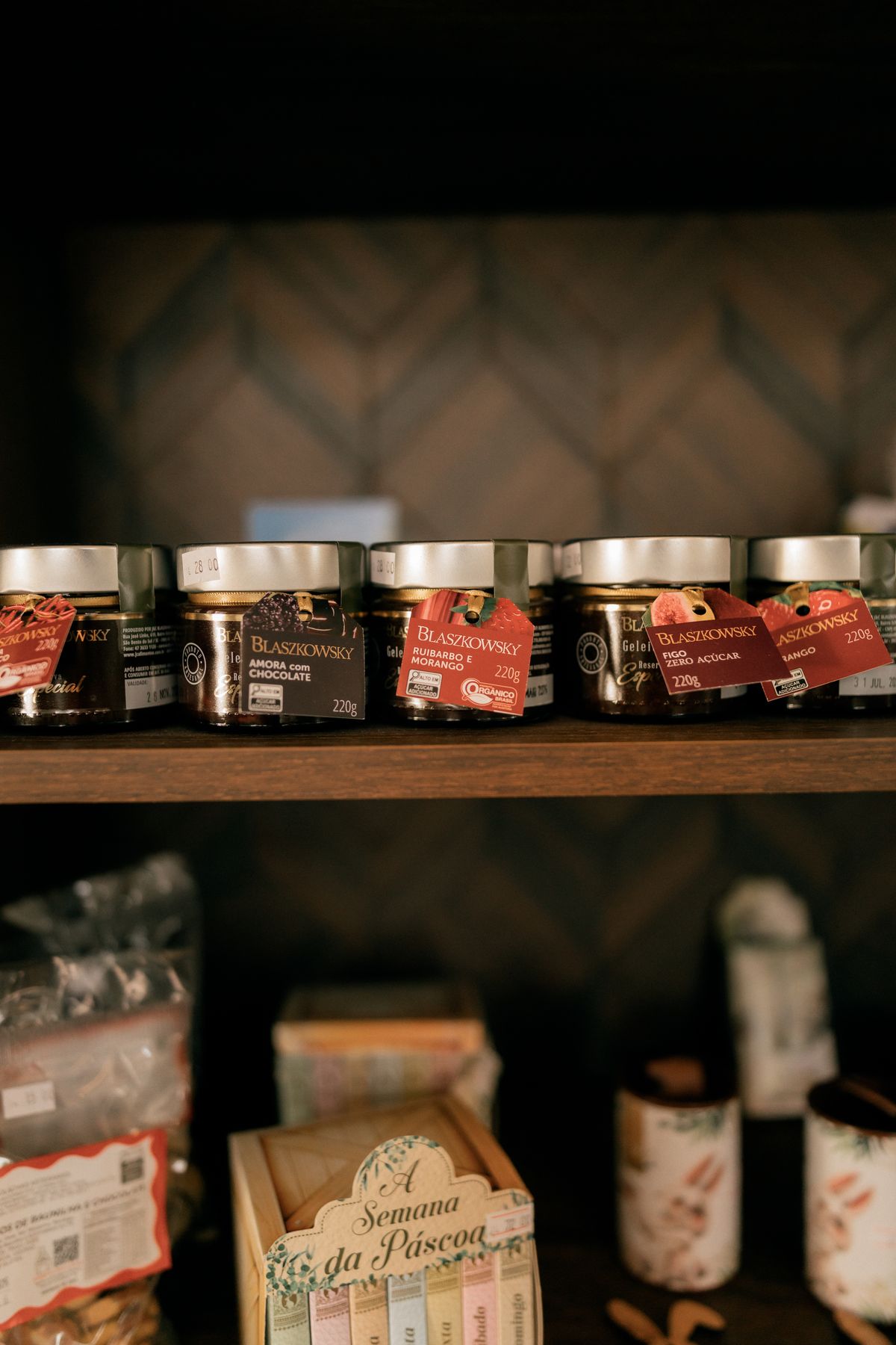 Jam jars with printed product labels on a shop shelf