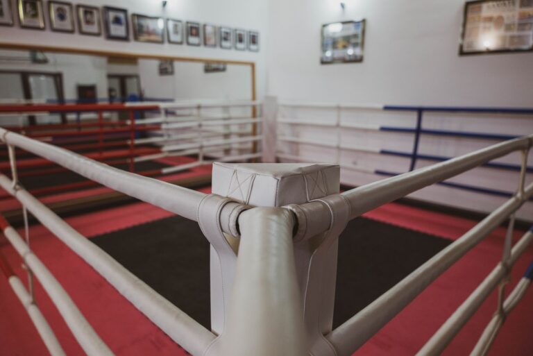 Empty boxing ring with framed photos on gym walls