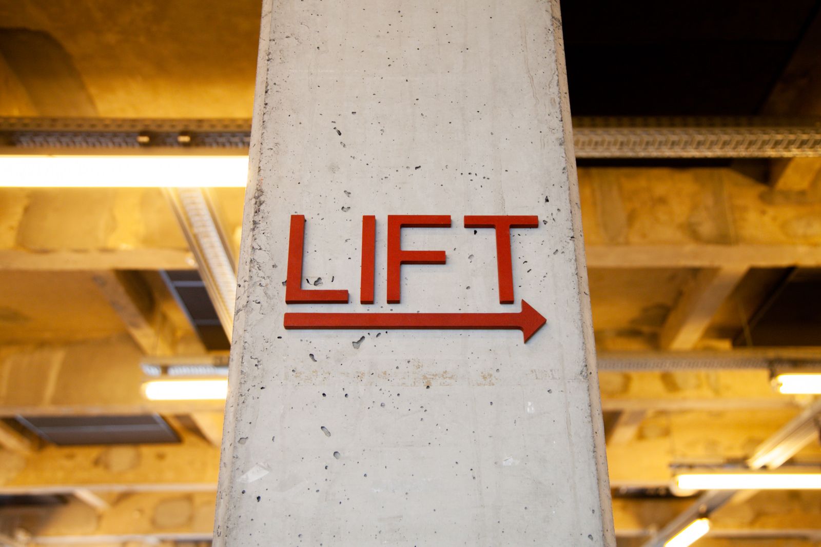 Indoor concrete pillar with directional wayfinding sign