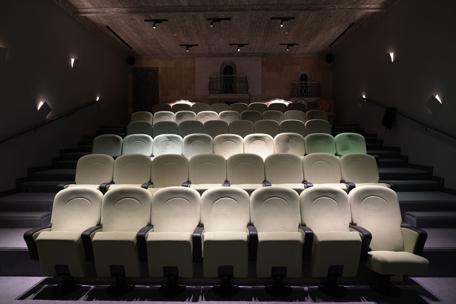 Empty theatre auditorium with rows of plush seating