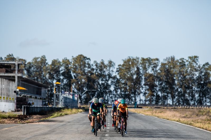 Group of cyclists riding together on an open road, generic kit