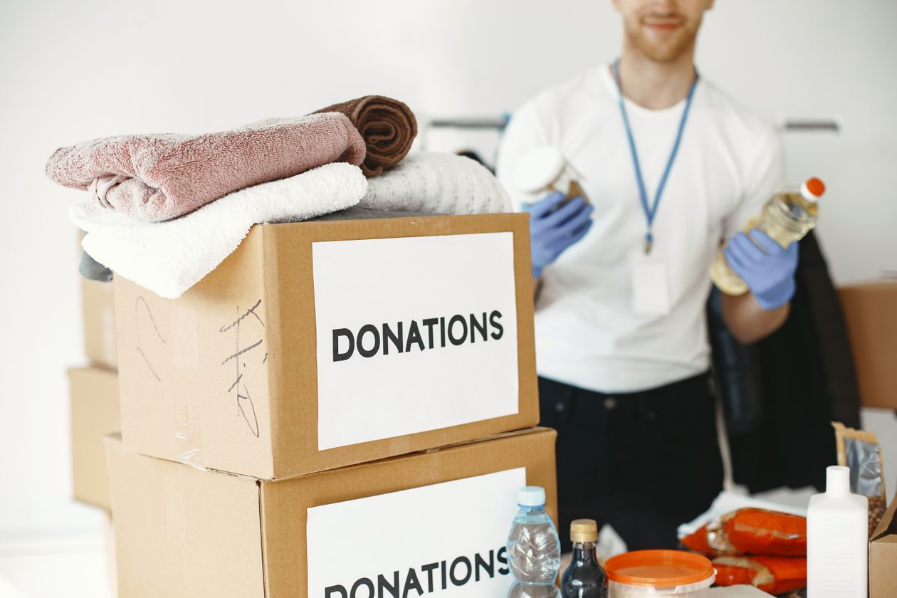 Volunteer sorting donation boxes filled with towels and household items