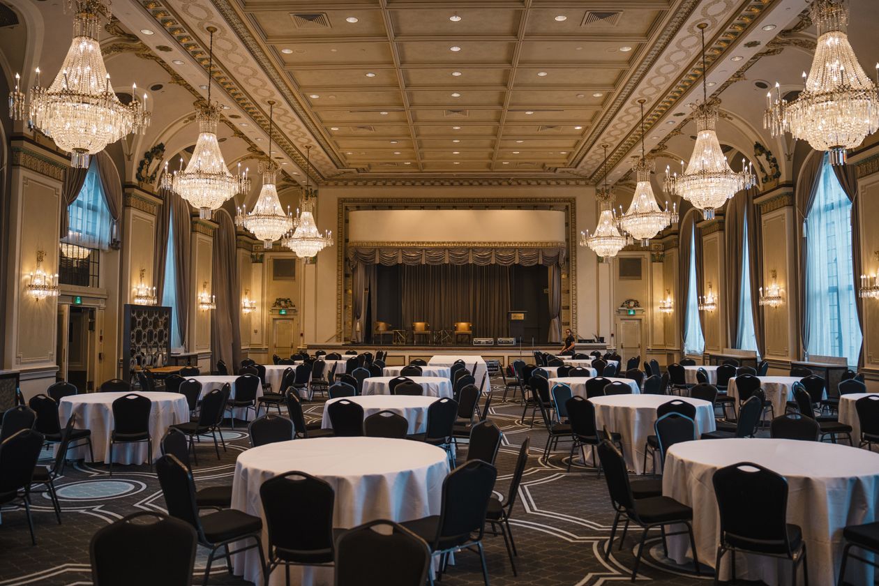 Elegant empty ballroom with crystal chandeliers set for a reception