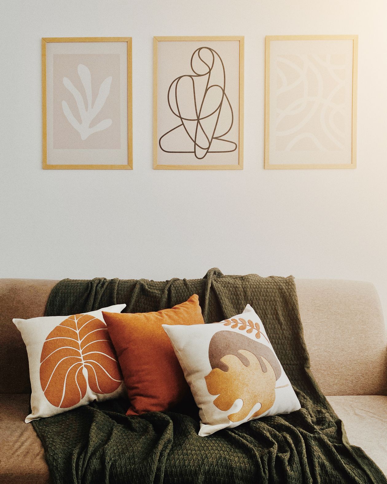 Framed line art prints displayed above a sofa