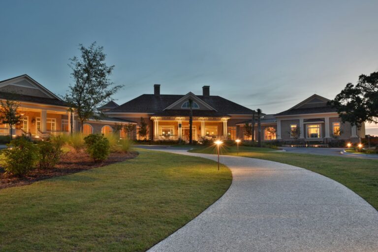 Golf clubhouse entrance with lit pathway at dusk