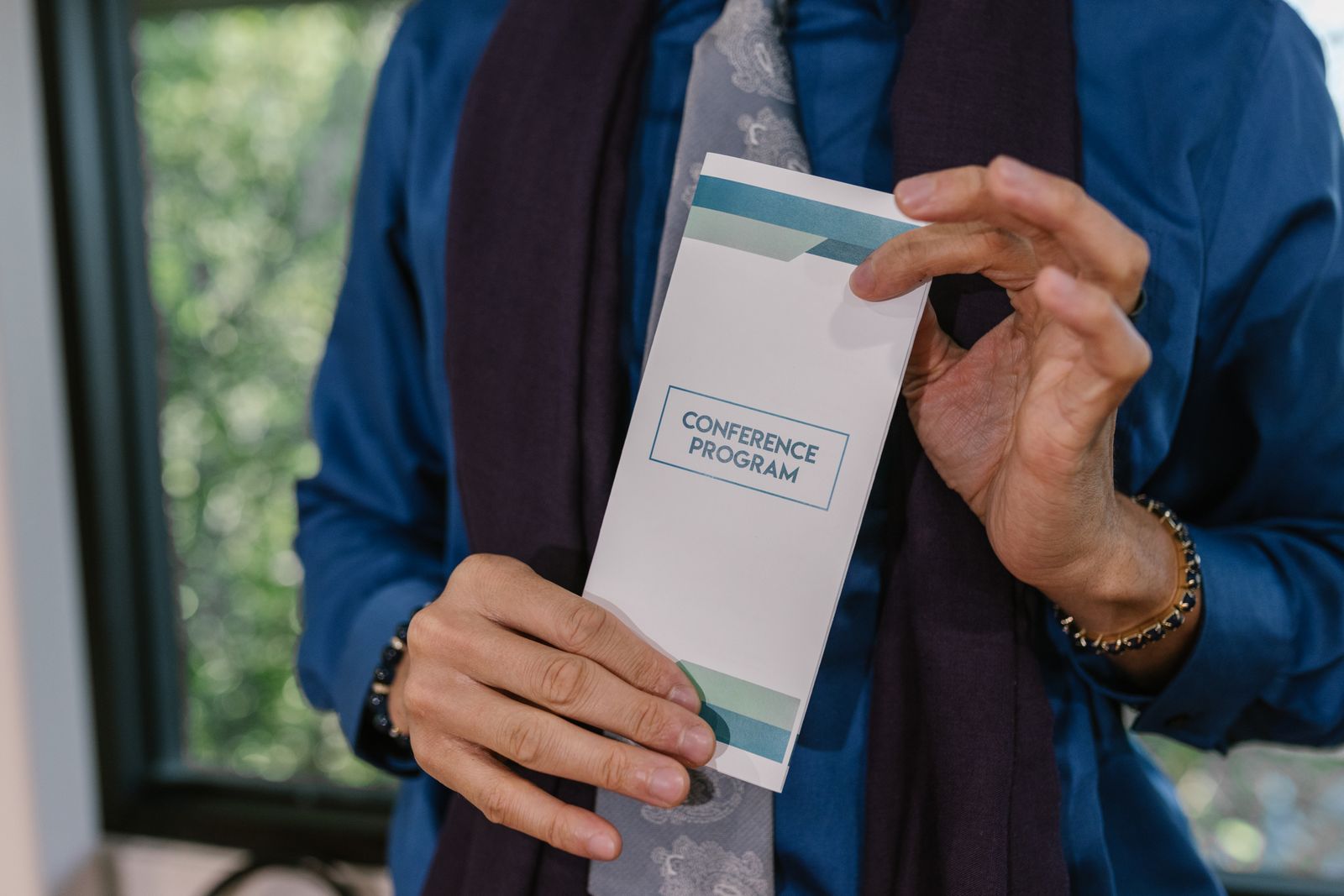 Hands holding an open printed programme