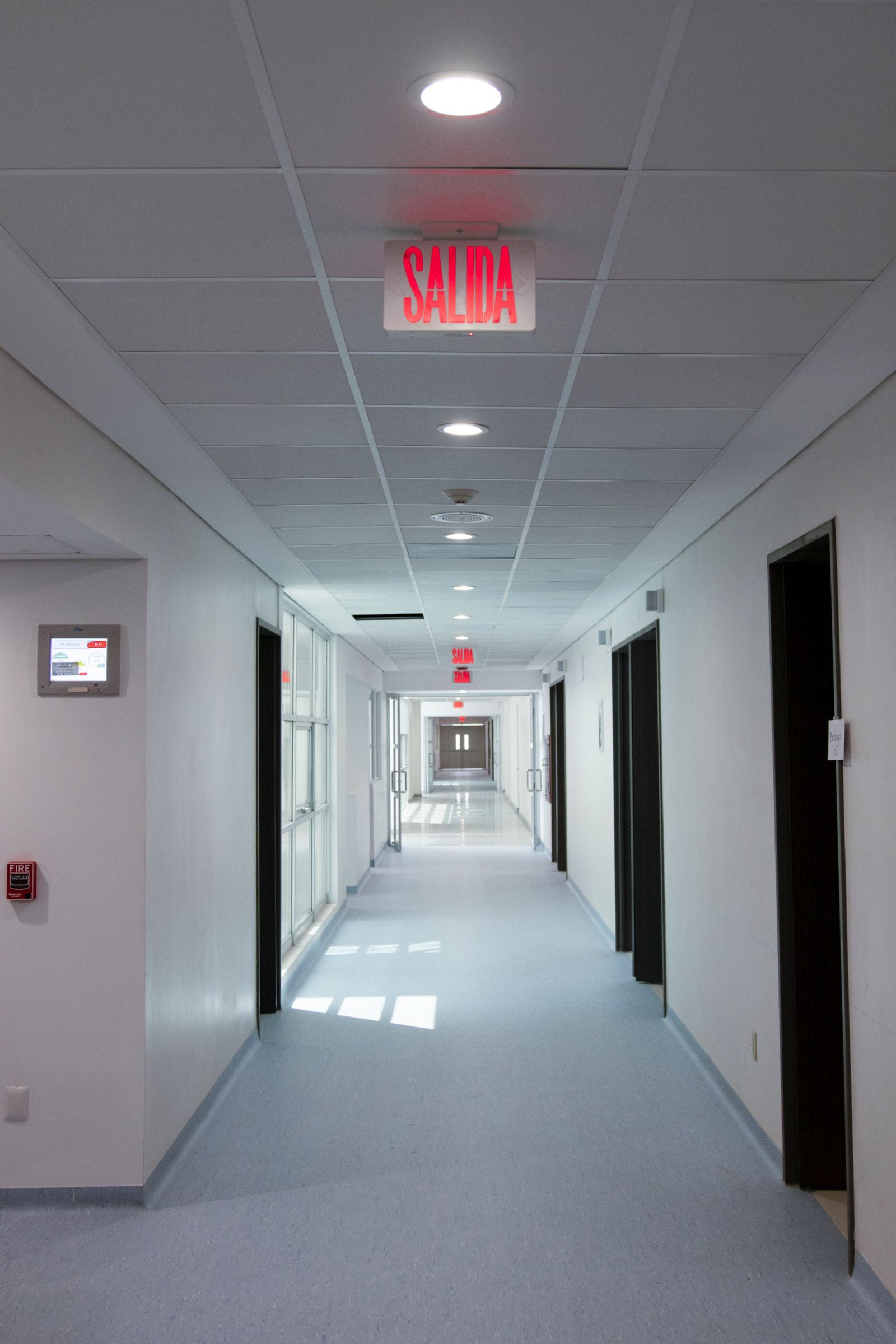Calm healthcare corridor with clear illuminated exit wayfinding sign