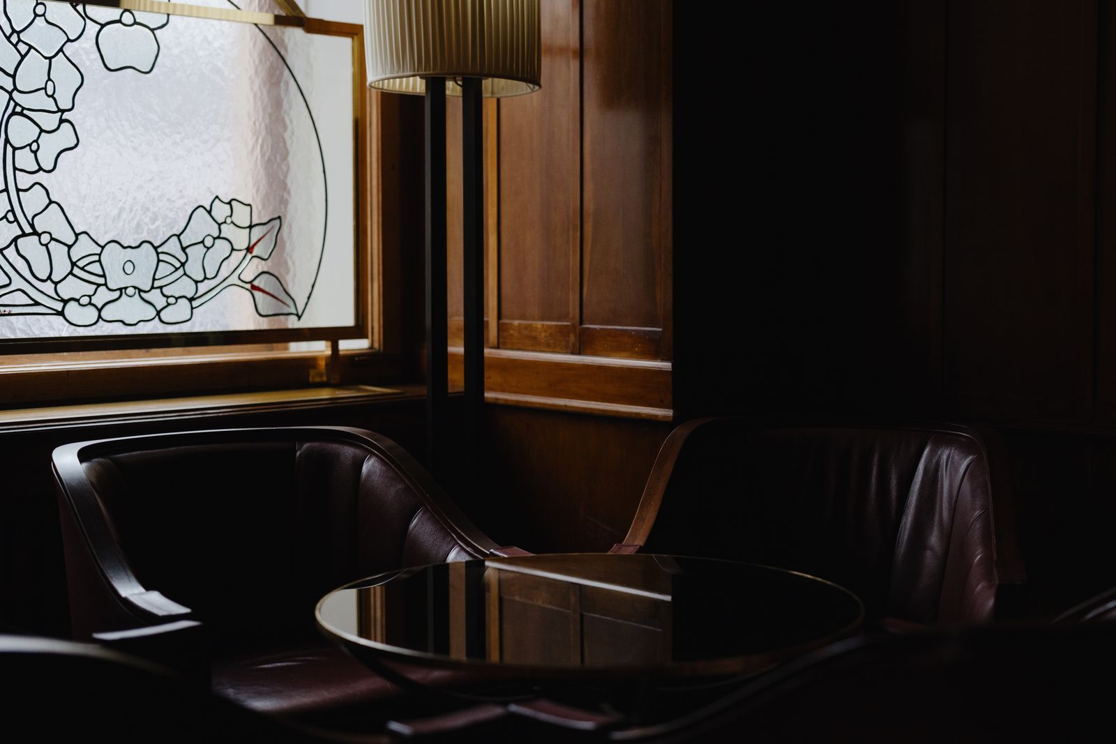 Lounge interior with dark wood panelling and stained glass window