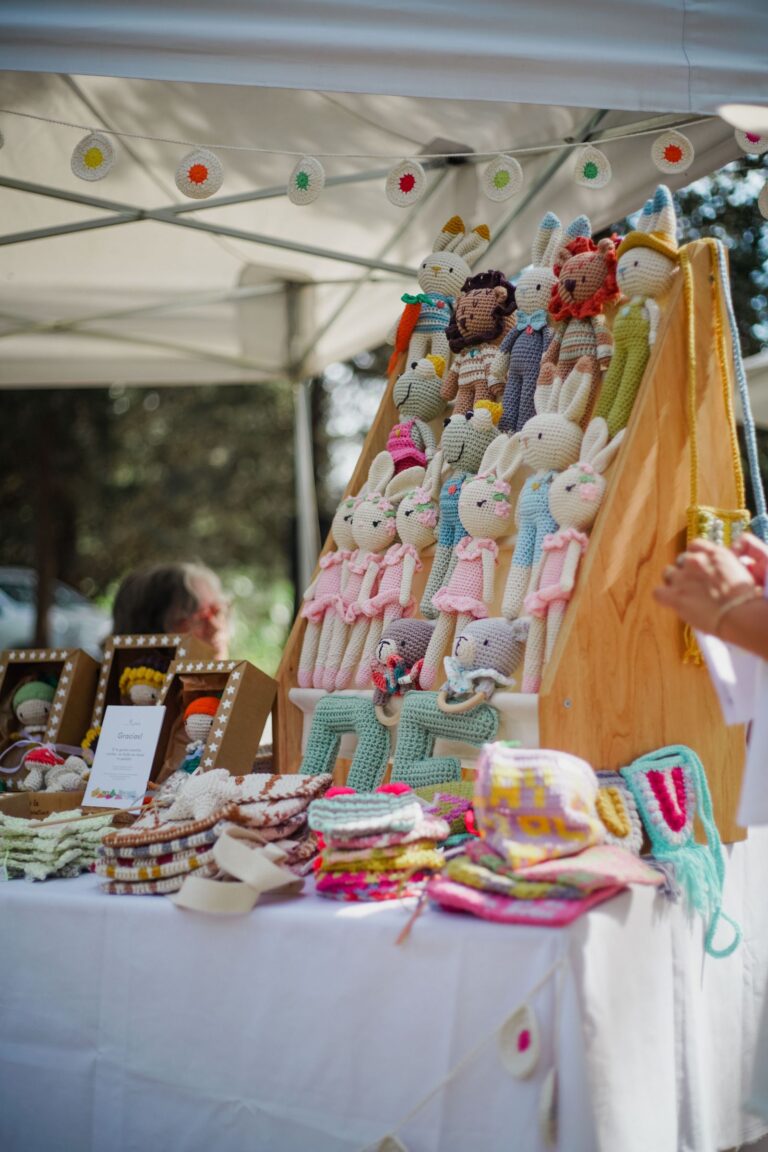 Outdoor market stall displaying colourful handmade cloth dolls