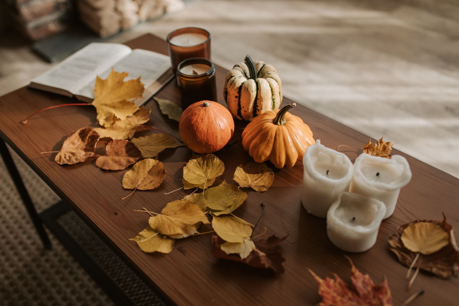 Pumpkins, candles and autumn leaves arranged on a table as a seasonal backdrop
