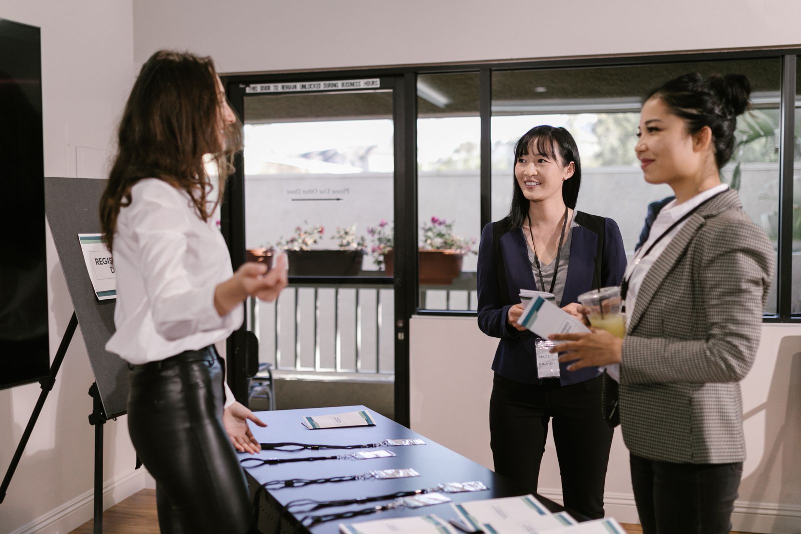 Conference attendees talking beside a registration desk with lanyards laid out