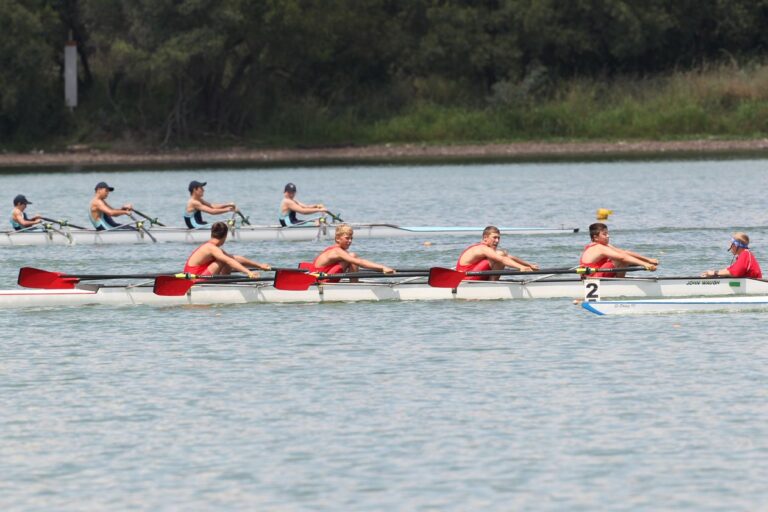 Rowing crews training on a river with a city skyline behind
