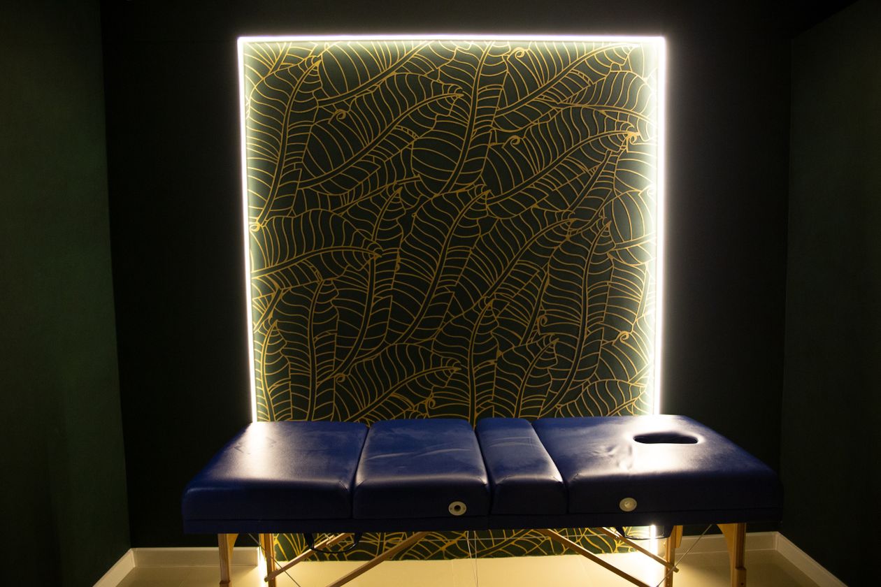 Treatment room with an illuminated printed wall panel behind the treatment table