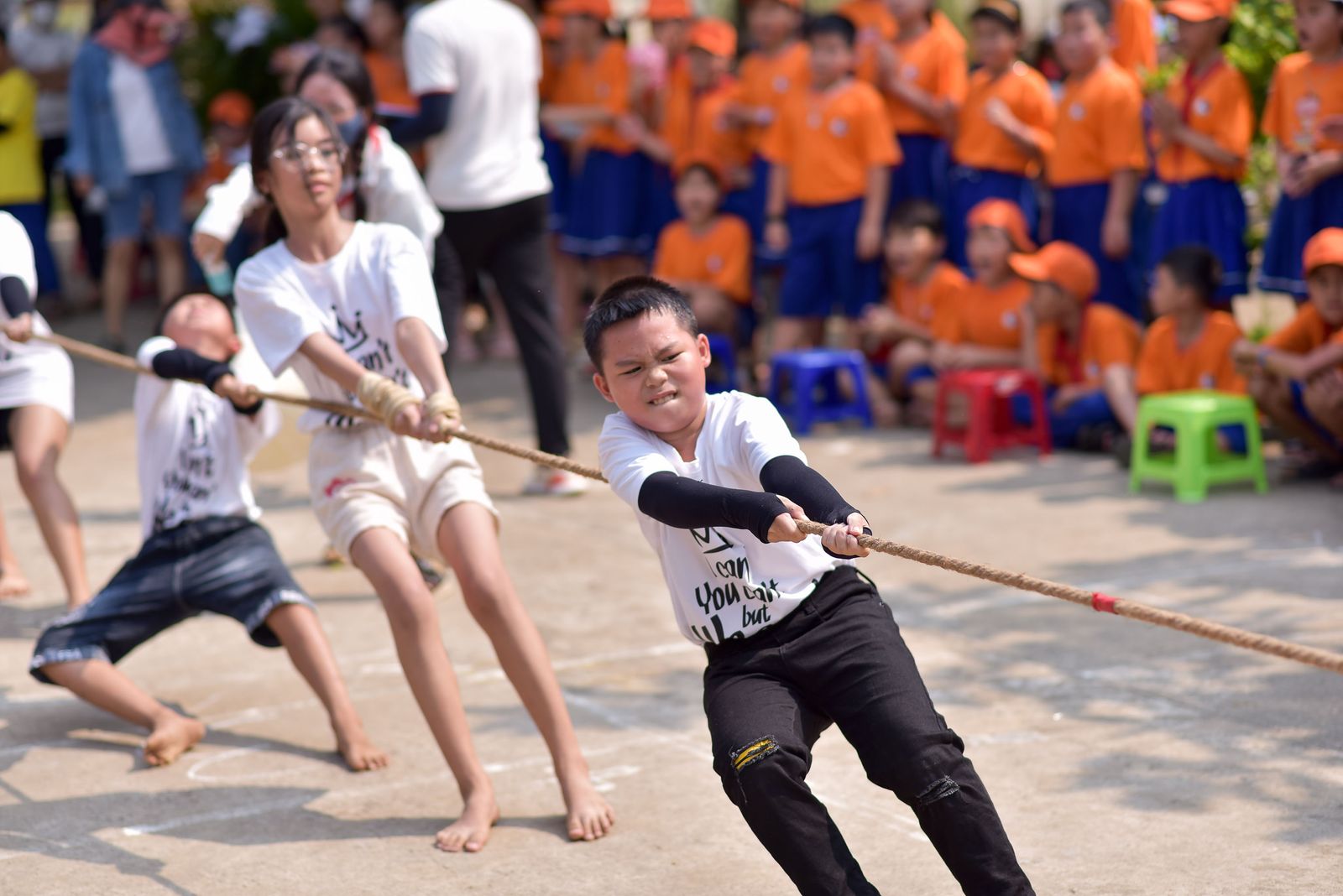School children playing tug of war outdoors on sports day