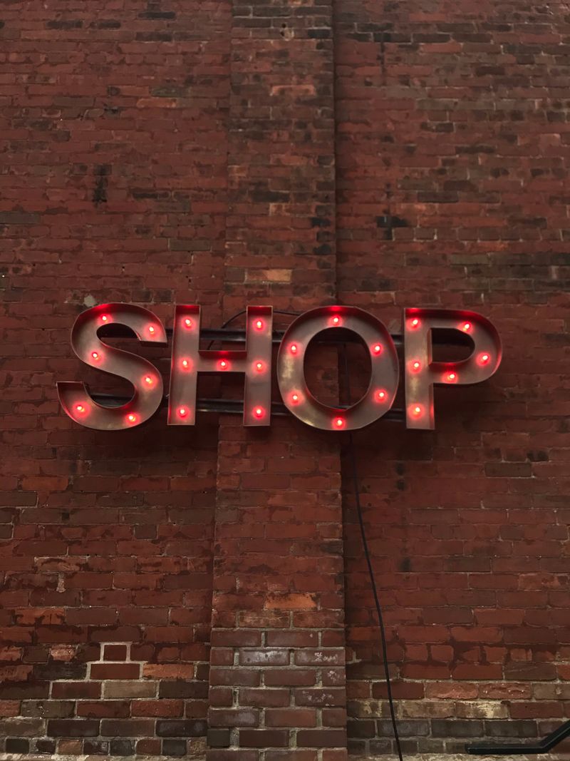 Illuminated SHOP letters mounted on a brick wall