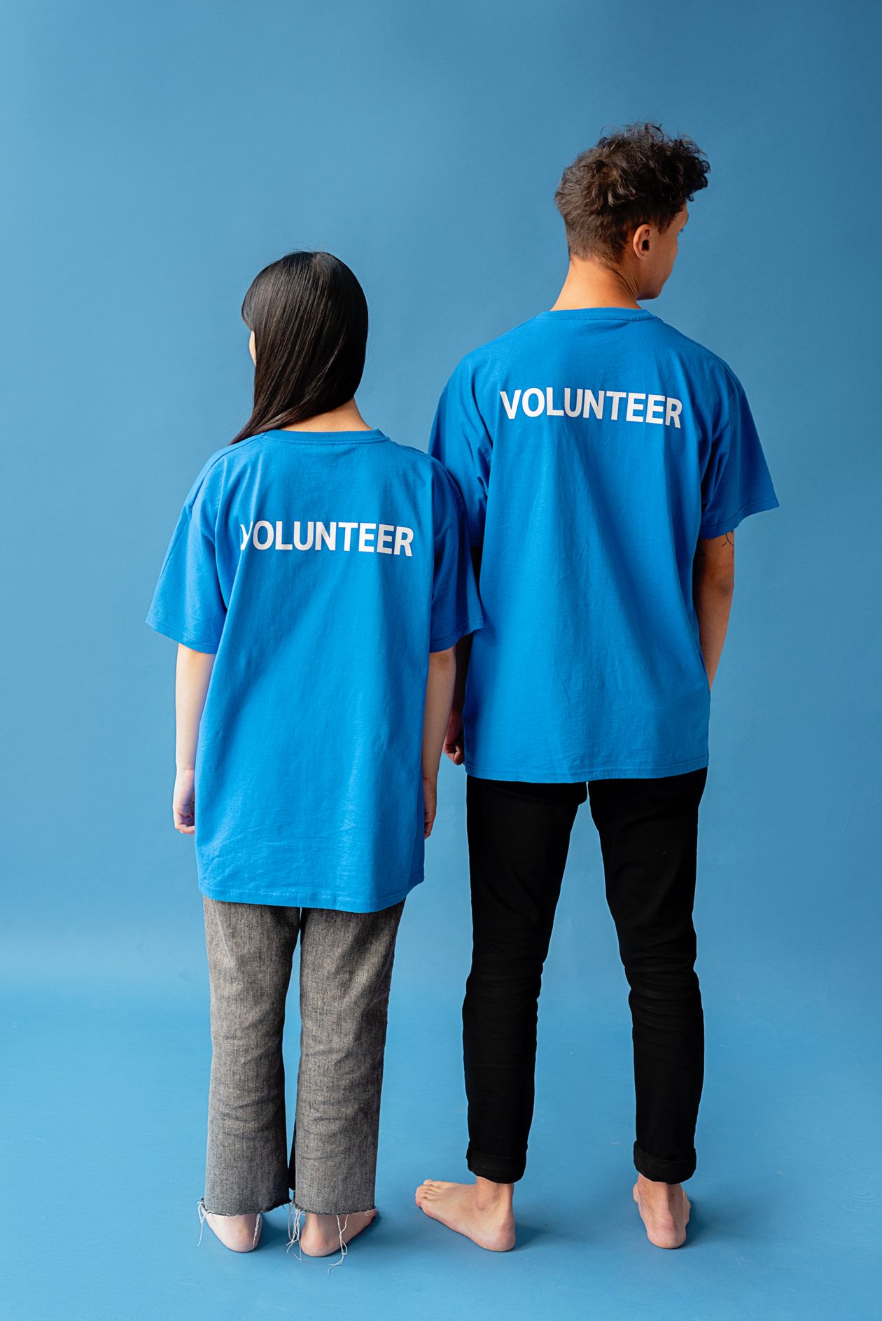 Volunteers wearing matching branded volunteer t-shirts, seen from behind