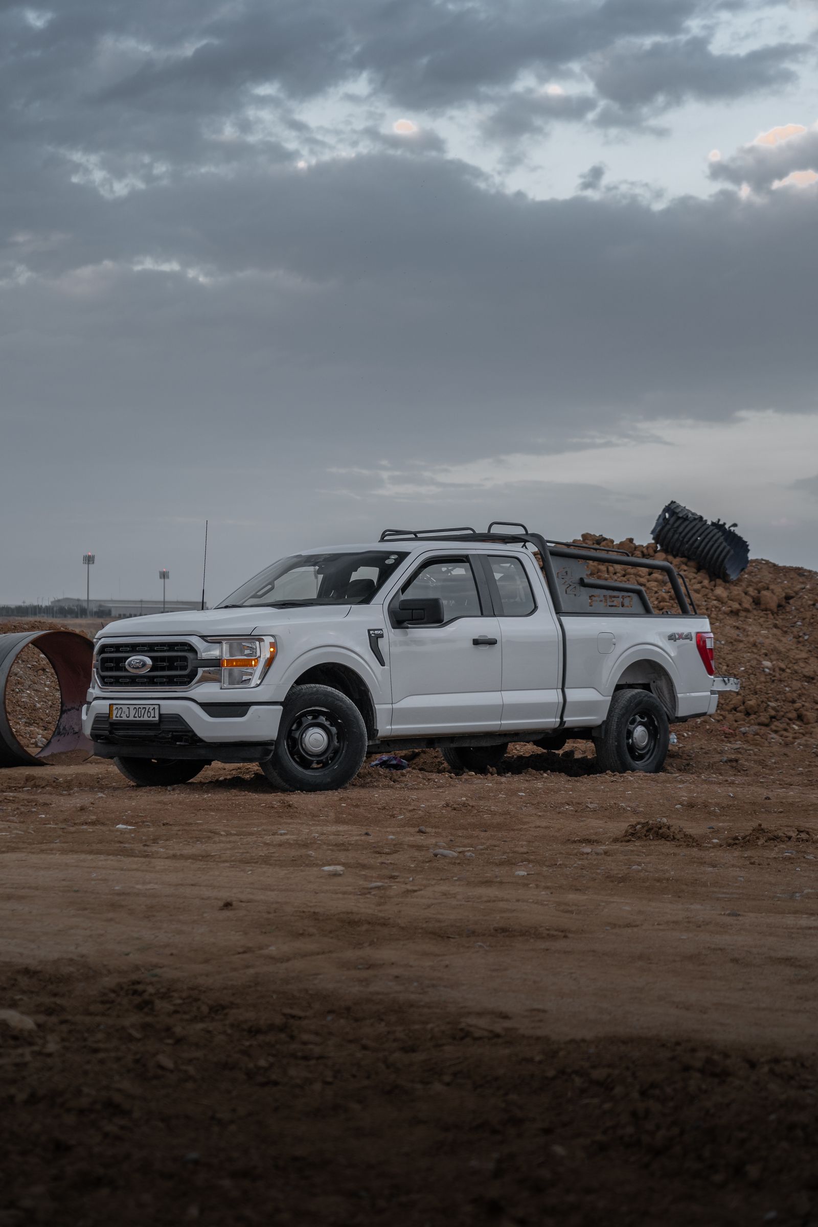 White pickup truck parked at a dusty construction site
