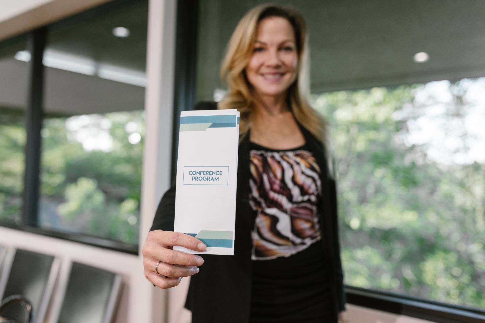 Woman holding a printed conference programme pamphlet