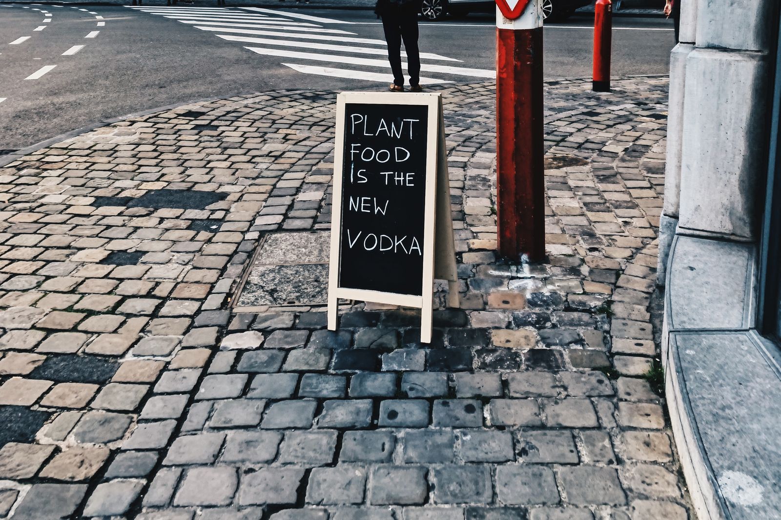 Wooden A-board sign on a cobblestone street