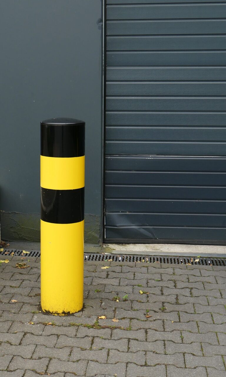 Yellow and black bollard beside a loading bay door