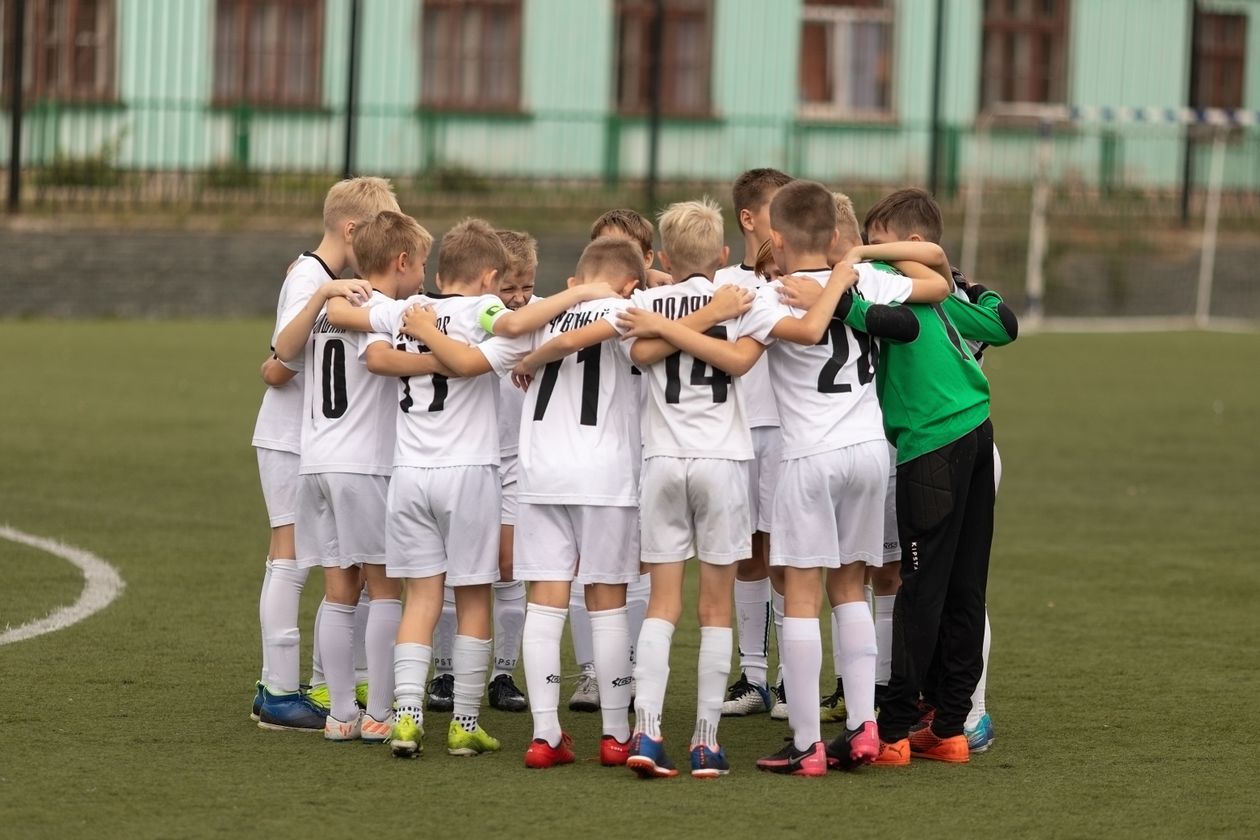 Youth football team in matching kit huddled together before a match