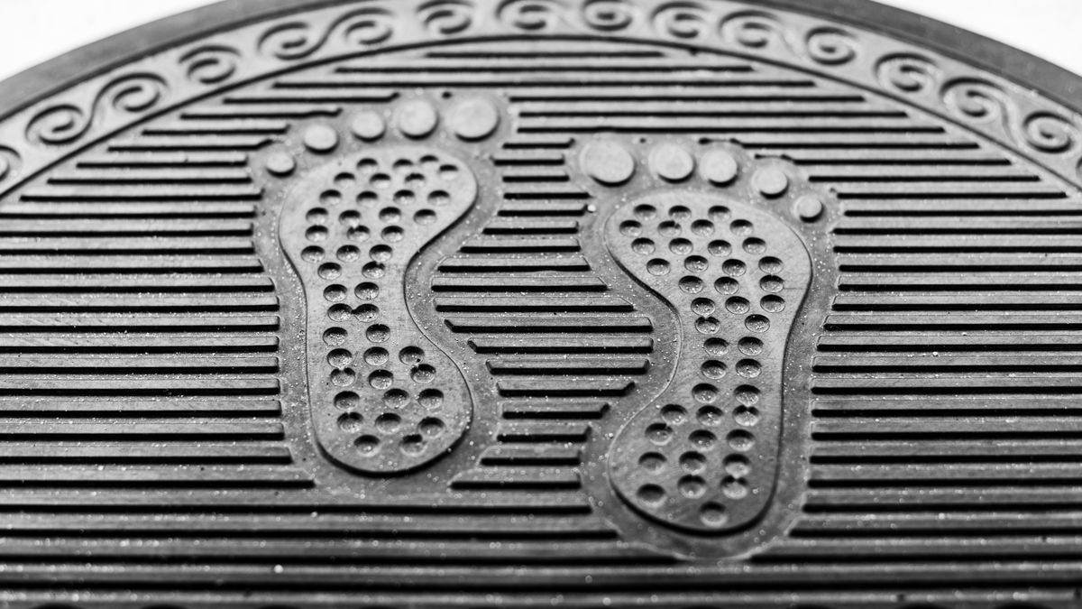 Textured black rubber commercial entrance mat with footprint design