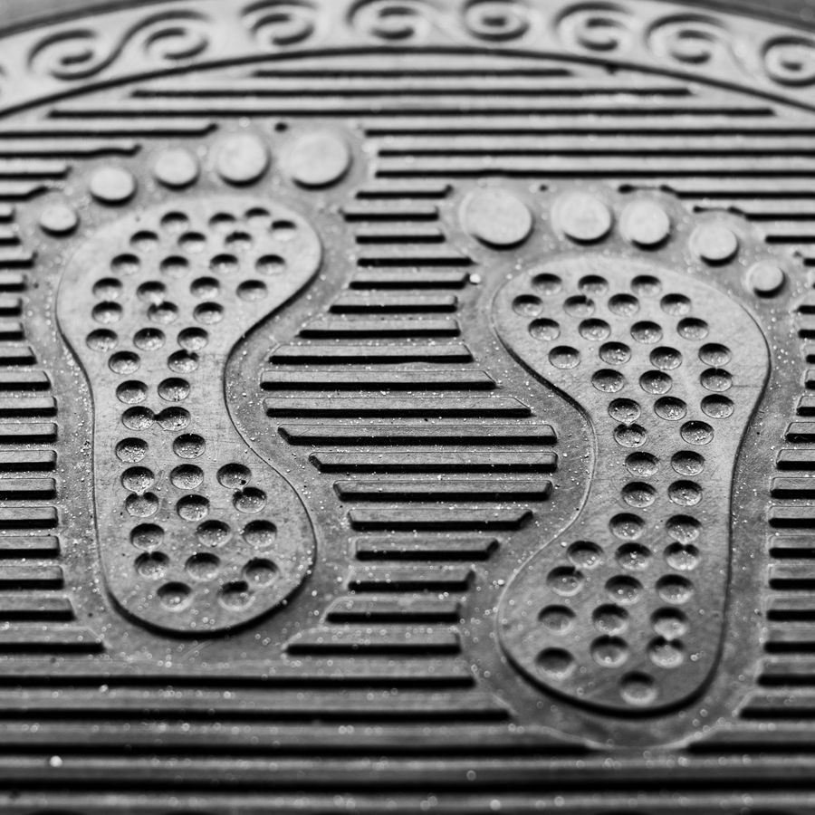 Textured black rubber commercial entrance mat with footprint design