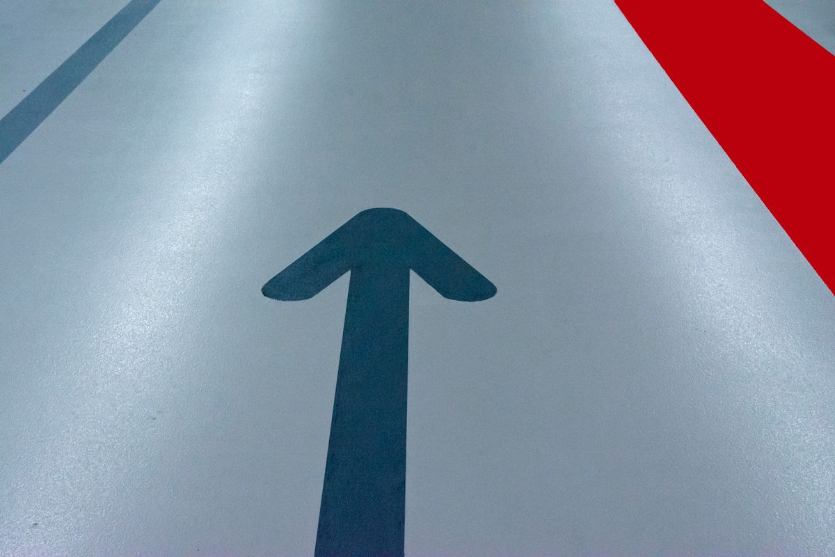 Blue directional arrow floor graphic in a parking garage