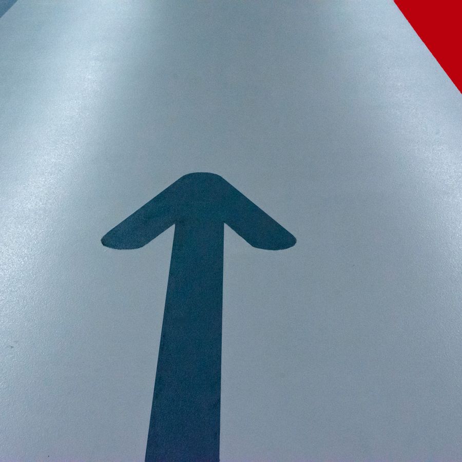 Blue directional arrow floor graphic in a parking garage
