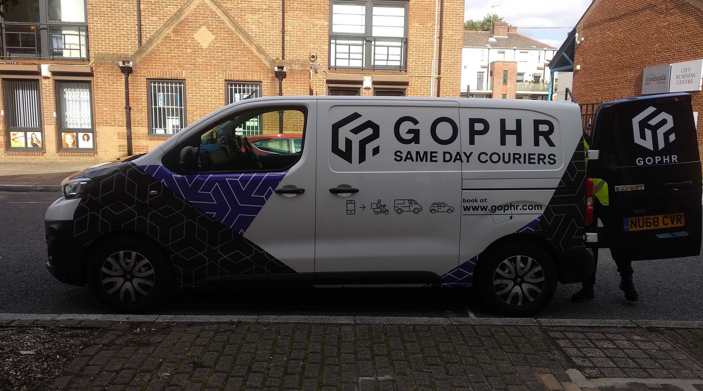 Partial vehicle wrap with geometric graphics on a Gophr same day courier van