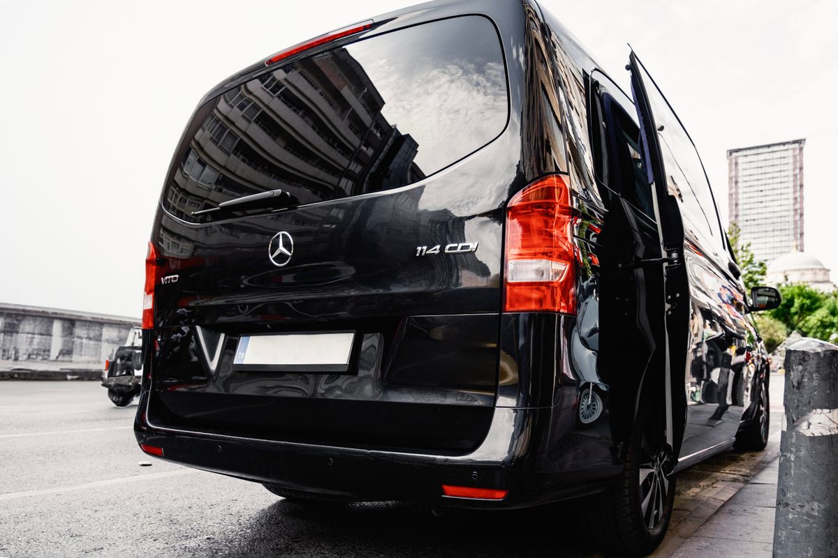 Rear view of a dark-coloured panel van parked on a city street