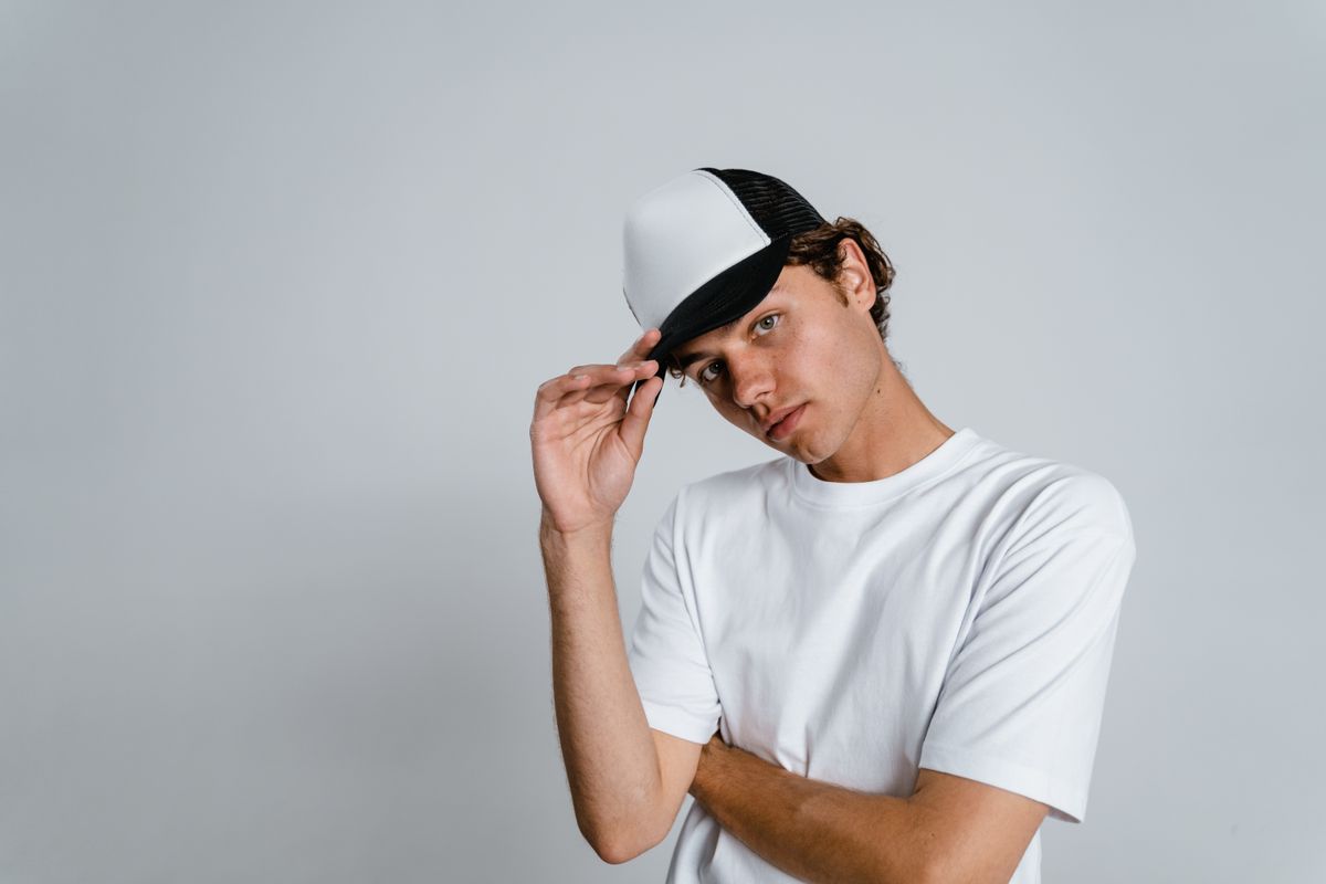 Man wearing a plain black and white trucker cap