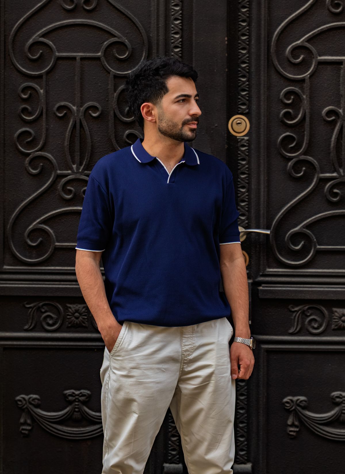 Man wearing a navy blue polo shirt with white tipped collar
