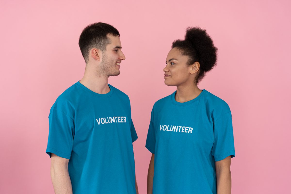 Two people wearing matching printed blue Volunteer event t-shirts